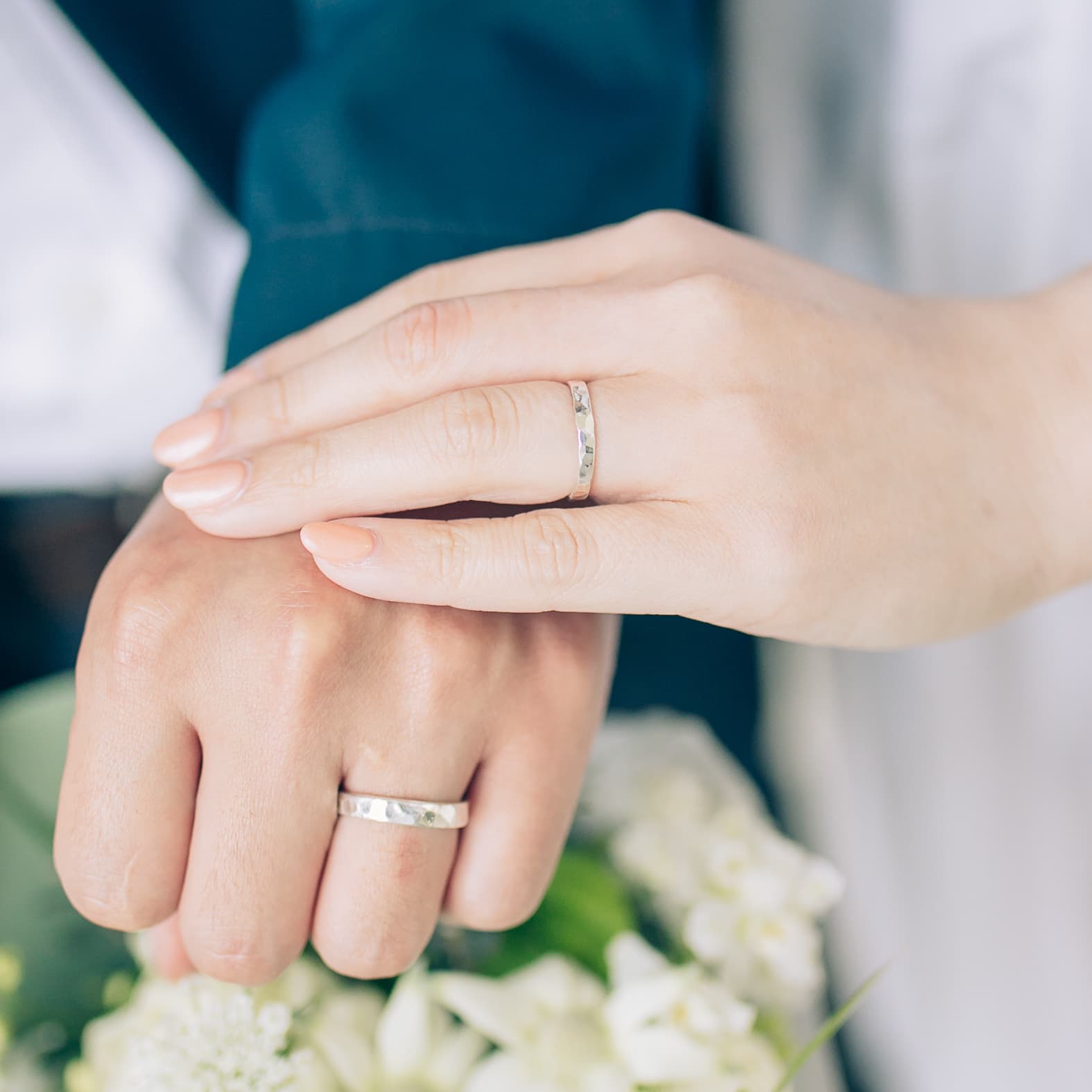 結婚指輪を重ねる手