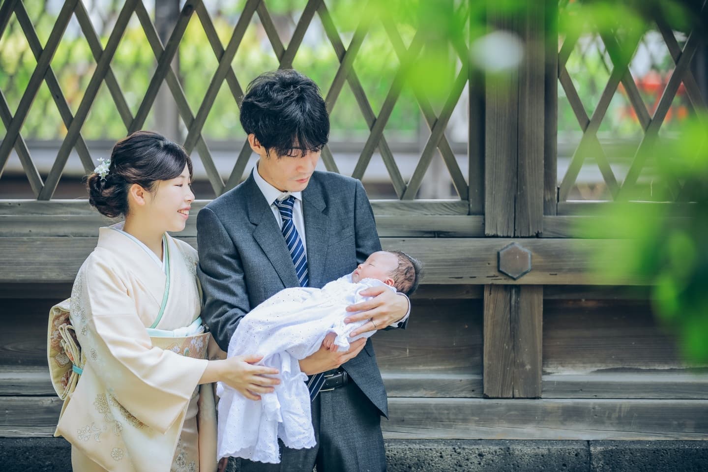 白い着物を着た女性とスーツの男性白いドレスを着た赤ちゃん