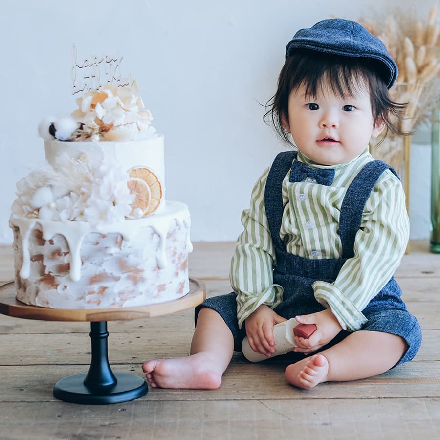 ストライプの服を着た男の子とバースデーケーキ