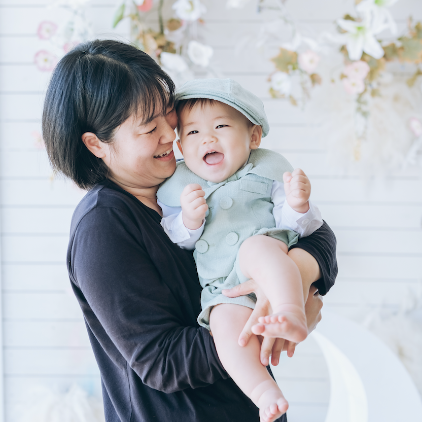 お母さんに抱っこされて幸せそうに笑う男の子