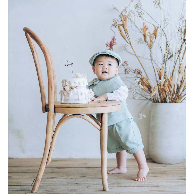 椅子に乗ったケーキを前に笑顔の男の子